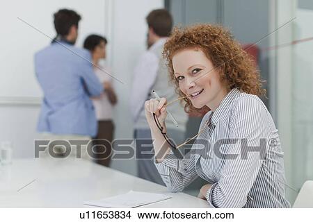 Picture - Businesswoman sitting in meeting. Fotosearch