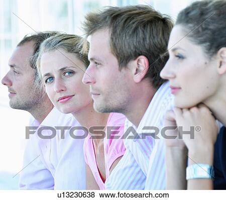 Stock Photo - Businesswoman sitting with colleagues. Fotosearch