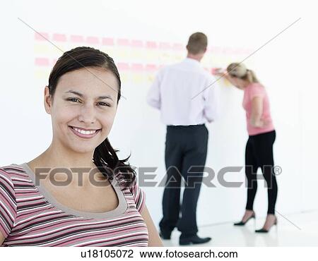 Stock Image - Businesswoman smiling in office. Fotosearch