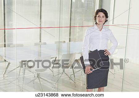 Stock Photo - Businesswoman standing in office. Fotosearch