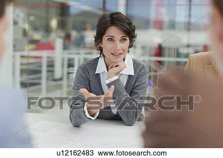 Stock Image - Businesswoman talking in meeting. Fotosearch