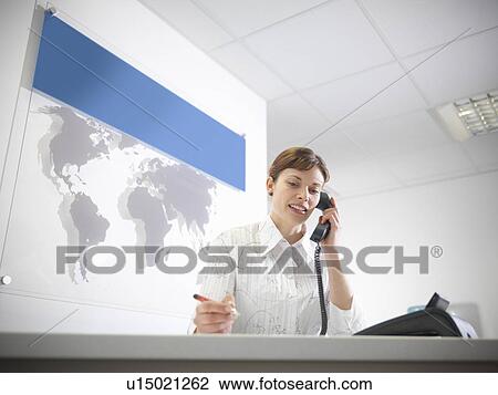 Businesswoman talking on phone at desk View Large Photo Image Stock Image - Businesswoman talking on phone at desk. Fotosearch