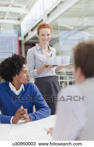 Stock Image - Businesswoman with tray of coffee. Fotosearch
