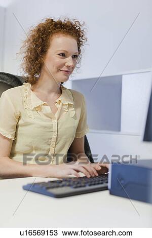 Stock Image - Businesswoman working at computer. Fotosearch