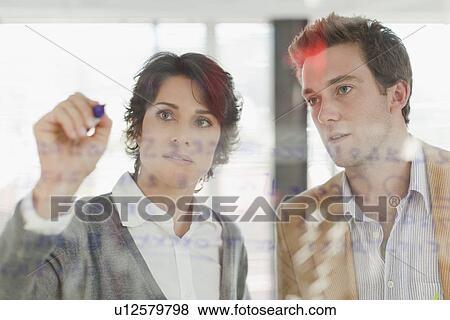Stock Photo - Businesswoman writing on glass. Fotosearch