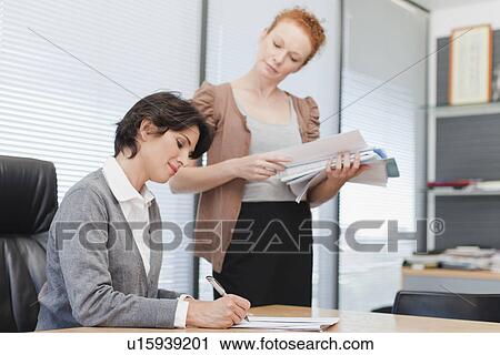 Businesswomen talking in office View Large Photo Image Stock Image - Businesswomen talking in office. Fotosearch