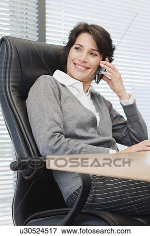Businesswomen talking on cell phone View Large Photo Image Stock Photo - Businesswomen talking on cell phone. Fotosearch