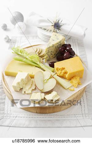 Stock Photograph - Cheese and fruit on wooden board. Fotosearch