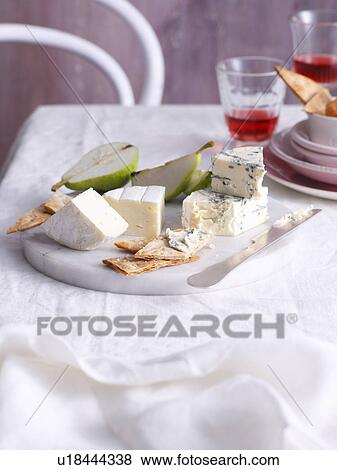 Stock Photo - Cheese, fruit and crackers on board. Fotosearch