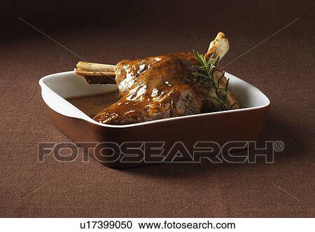 Stock Image - Close up of dish of lamb shanks. Fotosearch