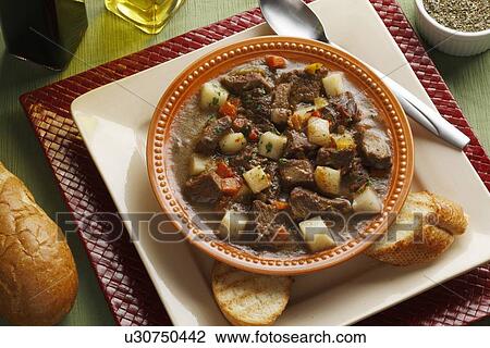 Stock Image - Close up of plate of stew and bread. Fotosearch