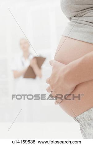 Close up of pregnant woman holding belly View Large Photo Image Stock Photo - Close up of pregnant woman holding belly. Fotosearch
