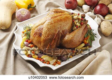 Stock Image - Close up of roast chicken and vegetables. Fotosearch
