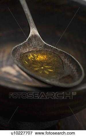 Stock Photo - Close up of spoonful of olive oil. Fotosearch