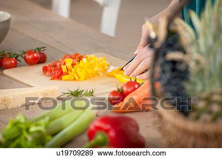 Stock Photo - Close up of woman chopping peppers. Fotosearch