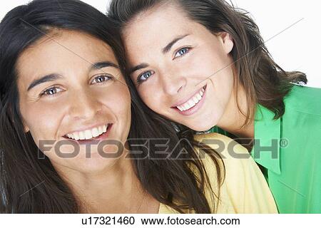 Stock Image - Close up of women smiling together. Fotosearch