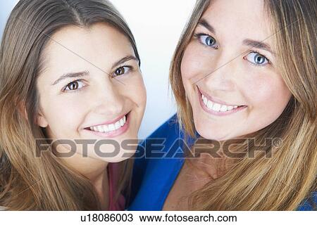 Stock Image - Close up of womens smiling faces. Fotosearch