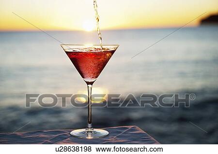 Cocktail pouring in glass outdoors View Large Photo Image Stock Photo - Cocktail pouring in glass outdoors. Fotosearch