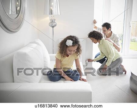 Couple adjusting radiator in living room View Large Photo Image Stock Image - Couple adjusting radiator in living room. Fotosearch