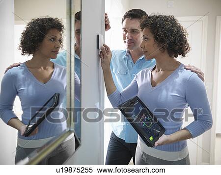 Couple adjusting thermostat in home View Large Photo Image Stock Photography - Couple adjusting thermostat in home. Fotosearch