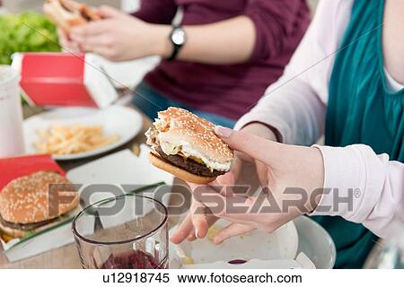 Stock Photography - Couple eating fast food together. Fotosearch
