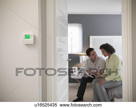Couple examining papers in bedroom View Large Photo Image Stock Photography - Couple examining papers in bedroom. Fotosearch
