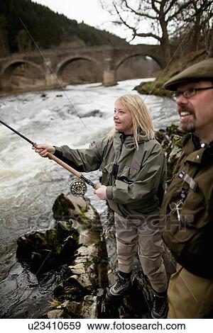 Couple fishing for salmon in river View Large Photo Image Stock Photo - Couple fishing for salmon in river. Fotosearch