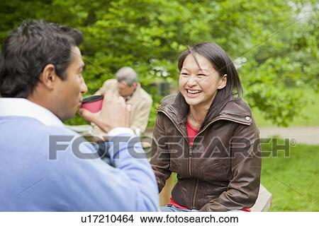Couple having coffee in park View Large Photo Image Picture - Couple having coffee in park. Fotosearch