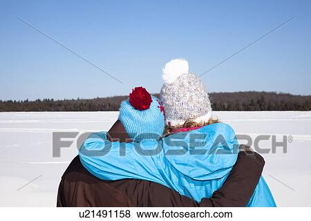 Couple hugging in snowy field View Large Photo Image Stock Photo - Couple hugging in snowy field. Fotosearch