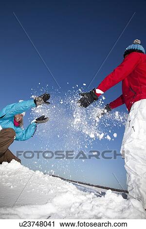 Couple playing with snow in field View Large Photo Image Stock Image - Couple playing with snow in field. Fotosearch