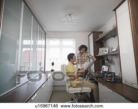 Couple talking in home office View Large Photo Image Stock Photograph - Couple talking in home office. Fotosearch
