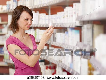 Stock Image - Customer browsing on drugstore shelves. Fotosearch