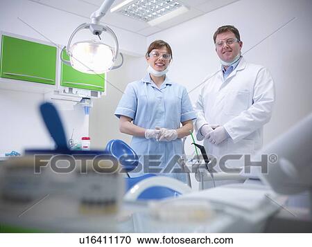 Stock Image - Dental student and dentist in surgery. Fotosearch