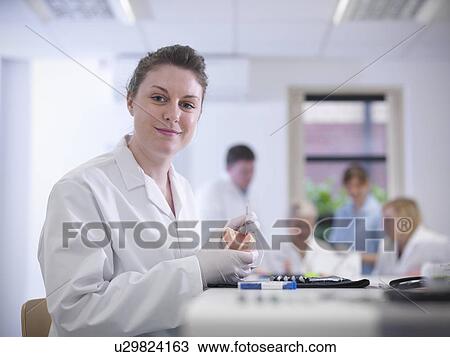 Stock Image - Dental student holding model of teeth. Fotosearch