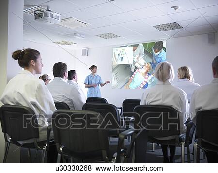 Stock Photo - Dentist teaching students in class. Fotosearch