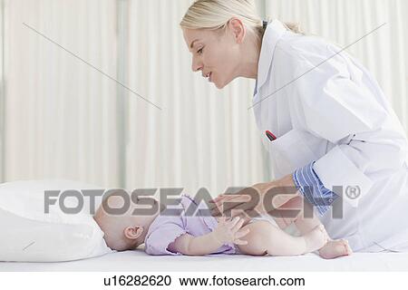 Stock Image - Doctor examining baby in office. Fotosearch