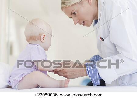 Stock Photograph - Doctor examining baby in office. Fotosearch