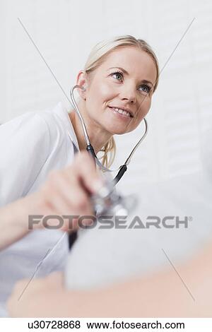 Doctor examining pregnant womans belly View Large Photo Image Stock Photo - Doctor examining pregnant womans belly. Fotosearch