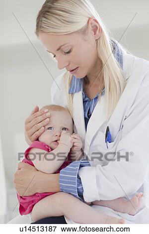 Stock Photo - Doctor hugging crying baby. Fotosearch