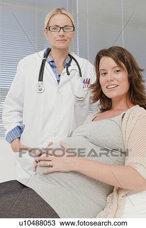 Doctor smiling with pregnant woman View Large Photo Image Stock Image - Doctor smiling with pregnant woman. Fotosearch