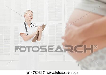 Stock Photo - Doctor talking to pregnant woman. Fotosearch