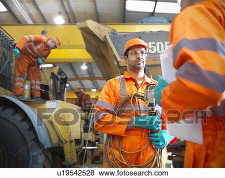 Stock Photo - Engineer talking to apprentice. Fotosearch