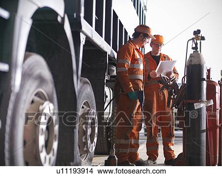 Picture - Engineer teaching apprentice outdoors. Fotosearch