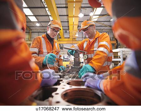 Engineer teaching apprentices in factory View Large Photo Image Stock Photo - Engineer teaching apprentices in factory. Fotosearch