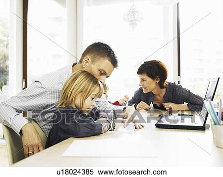 Family relaxing at dining room table View Large Photo Image Stock Photography - Family relaxing at dining room table. Fotosearch
