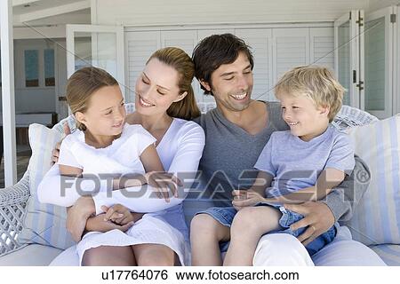 Family relaxing on sofa together View Large Photo Image Stock Photograph - Family relaxing on sofa together. Fotosearch