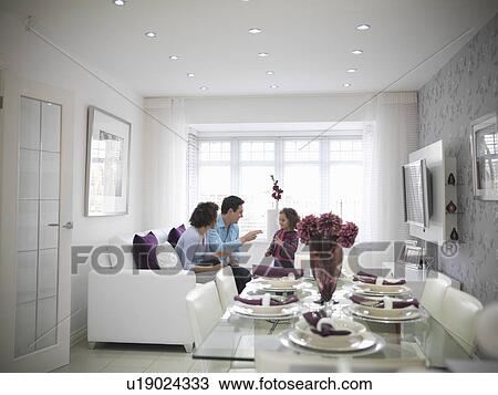 Family relaxing together in living room View Large Photo Image Stock Image - Family relaxing together in living room. Fotosearch