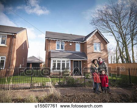 Stock Image - Family smiling outside house. Fotosearch