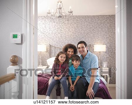 Family smiling together in bedroom View Large Photo Image Stock Photo - Family smiling together in bedroom. Fotosearch