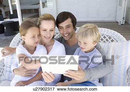 Family using tablet computer together View Large Photo Image Stock Photo - Family using tablet computer together. Fotosearch